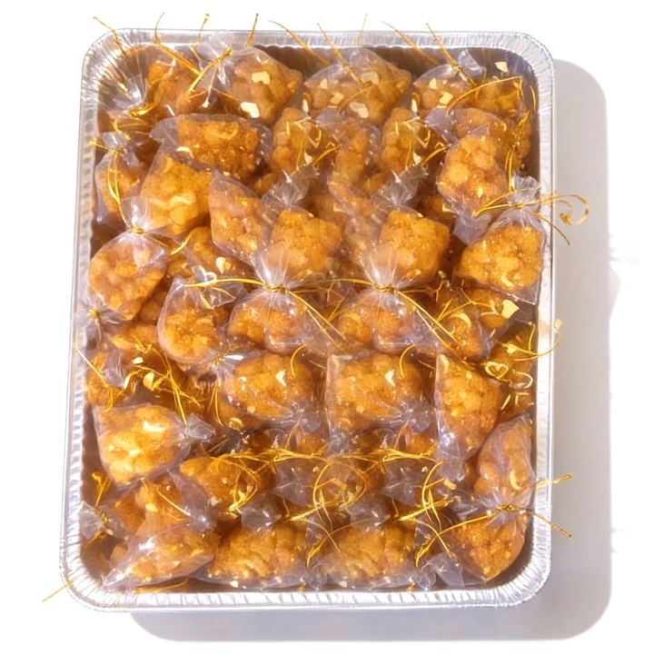 A tray of Chinchin party favor bags tied with gold ribbon